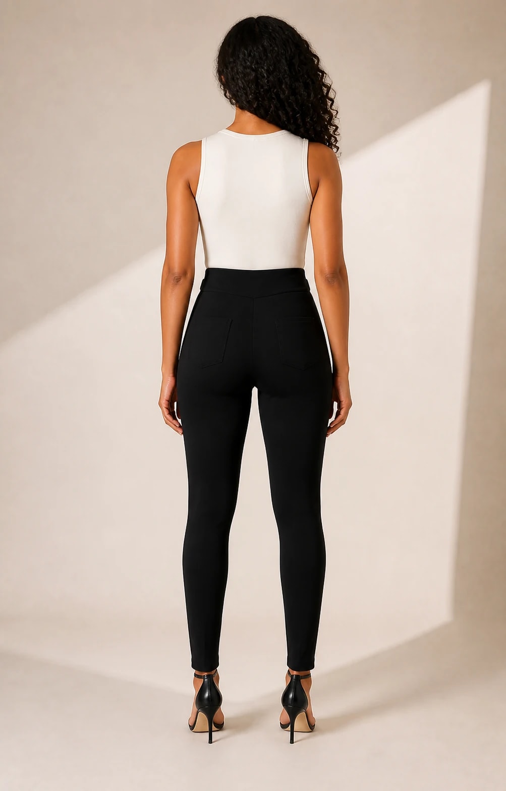 Pantalon hebillas doradas en negro, vista de espalda en modelo